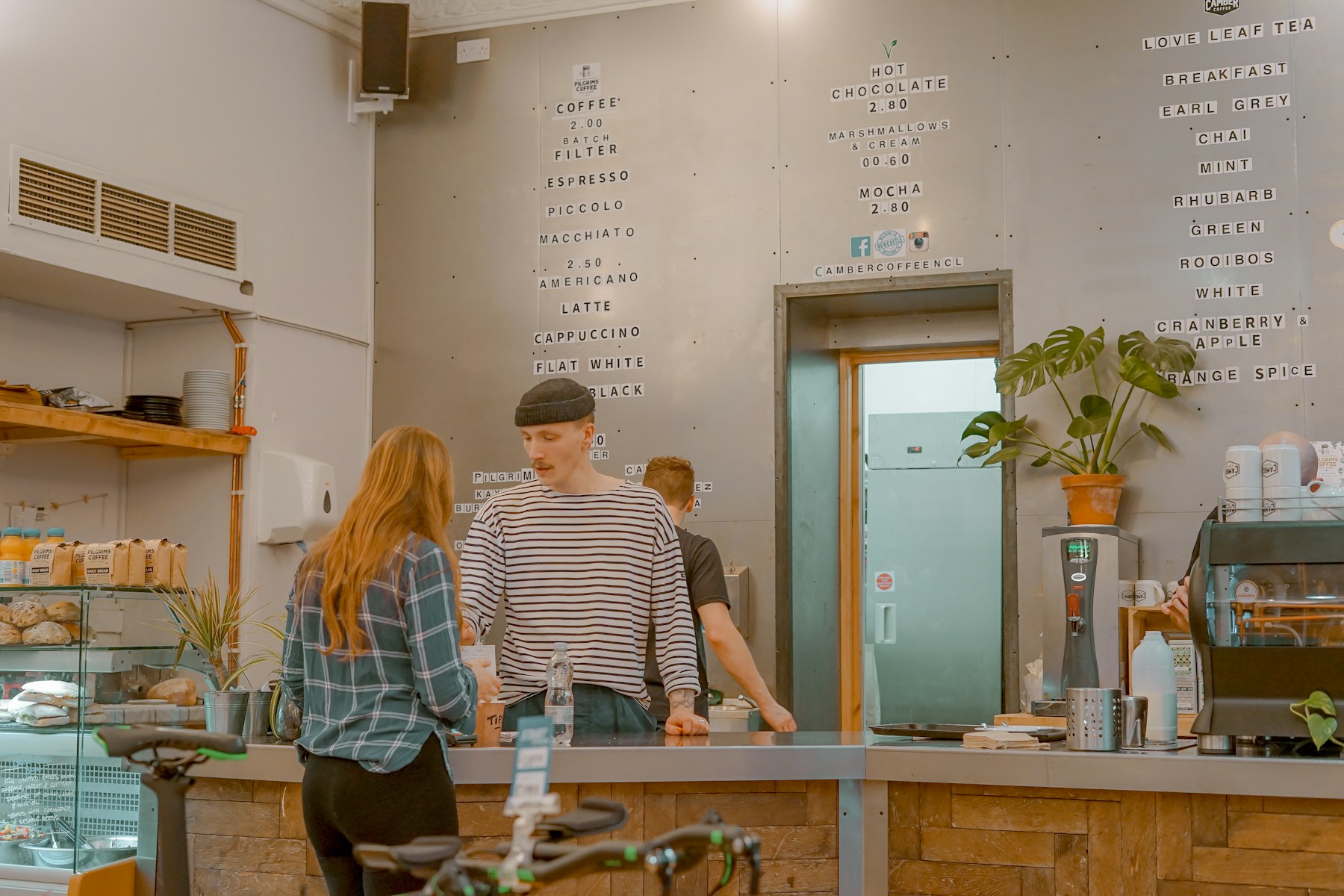 Zwei Menschen stehen in einem Café und sprechen miteinander